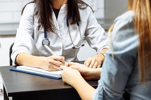 A doctor is noting down the health condition of the patient