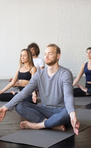 A person is sitting on the mat and meditating